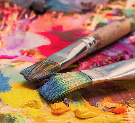 Paint brushes on top of a paint covered board
